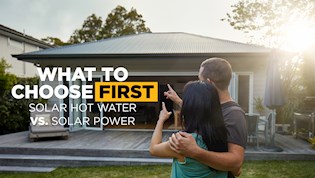 Couple pointing at their roof and discussing where to install solar panels